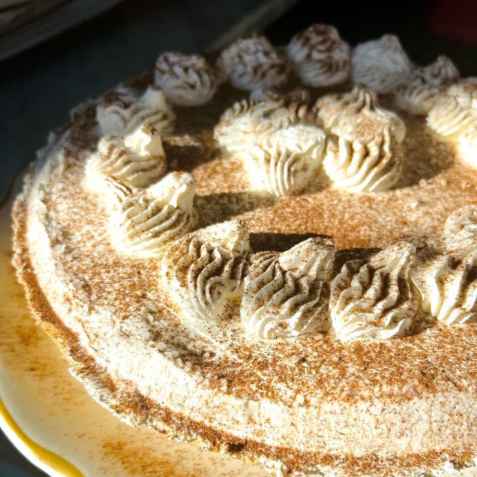Close-up of a Hildebrandt's ice cream cake with whipped cream swirls and cinnamon dusting.