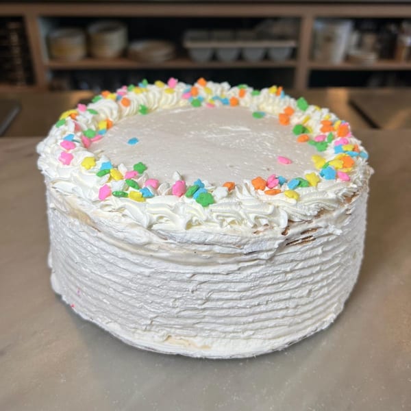 A white frosted Hildebrandt's ice cream cake with colorful star-shaped sprinkles on top.