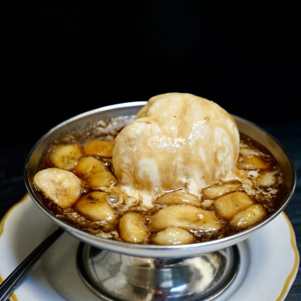Hildebrandt's banana split with vanilla ice cream and caramel sauce in a metal bowl.